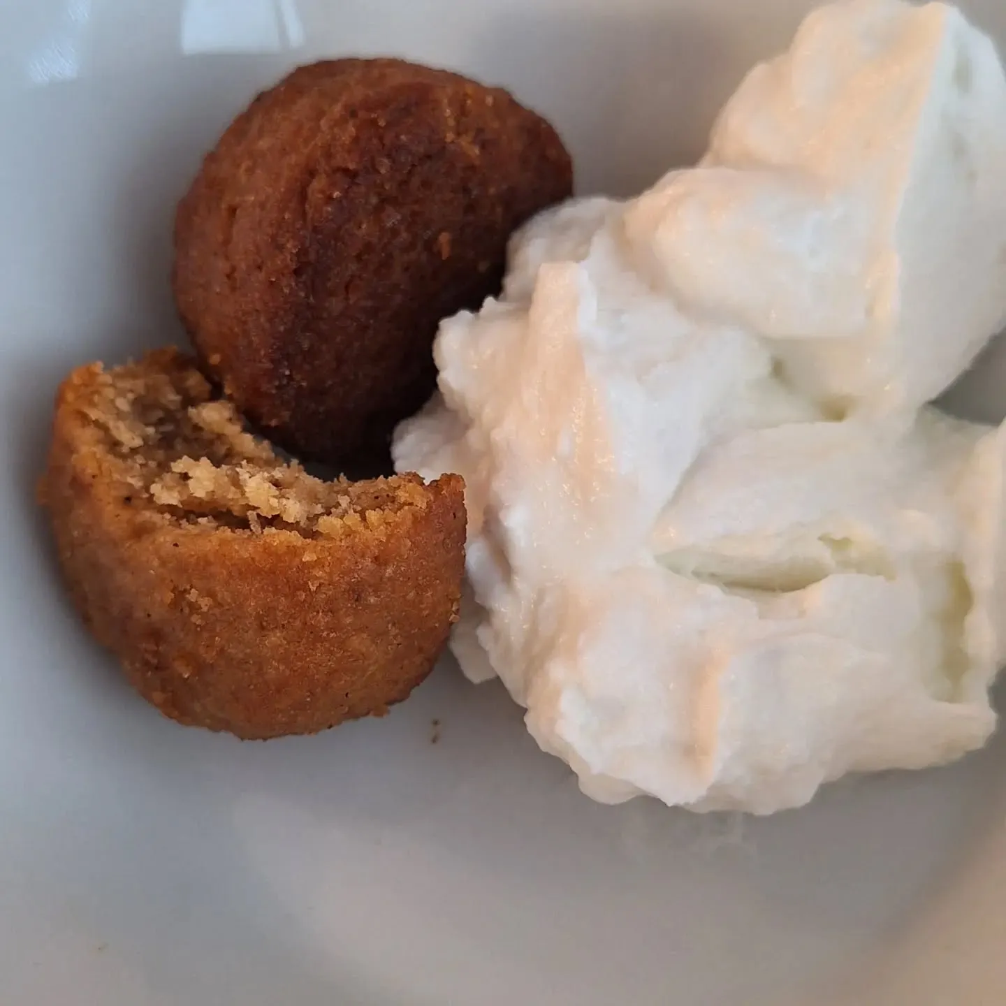 Melomakarona ao lado de uma porção de iogurte grego num prato