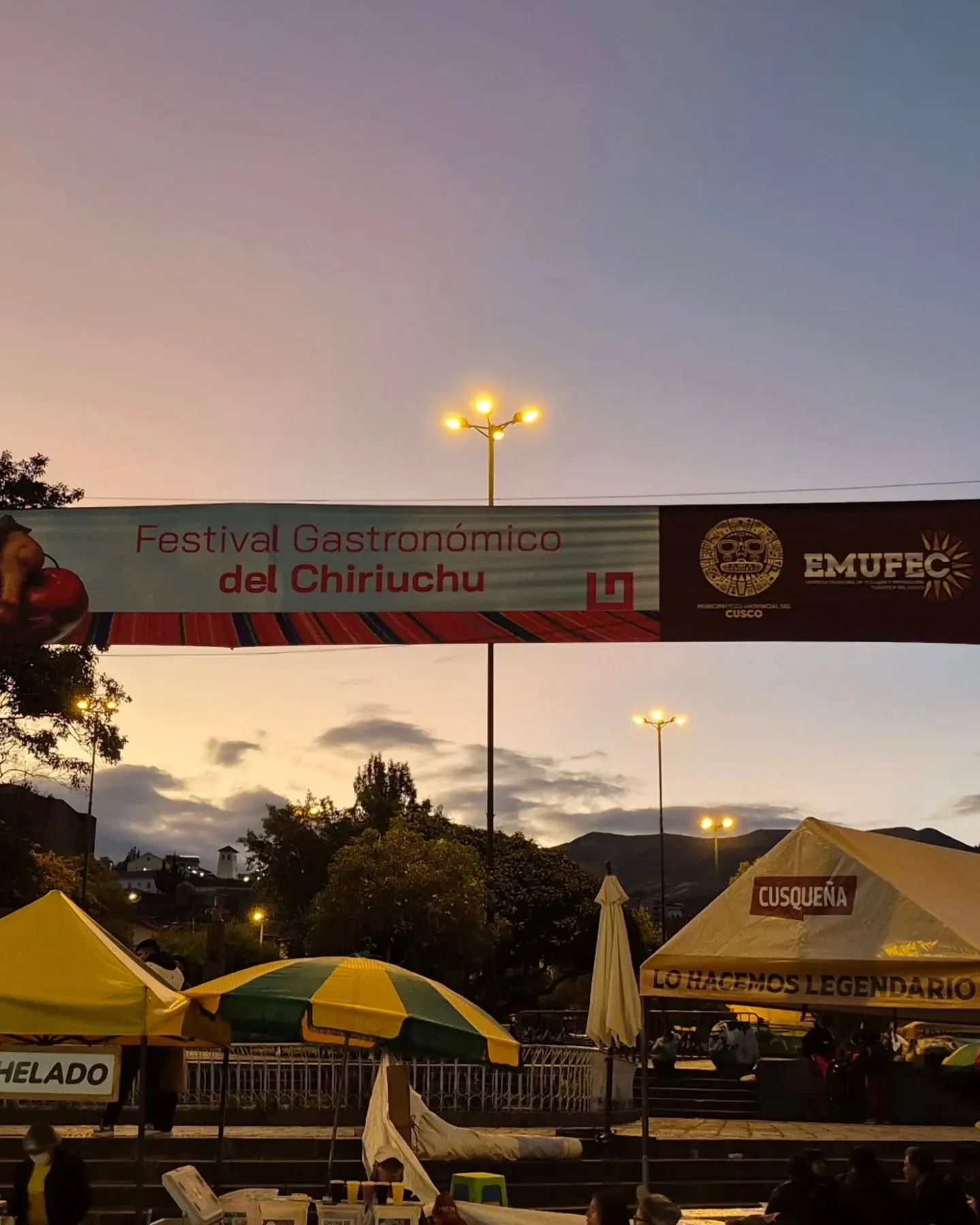 Entrada do Festival Gastronômico do Chiriuchu em Cusco ao entardecer, com barracas