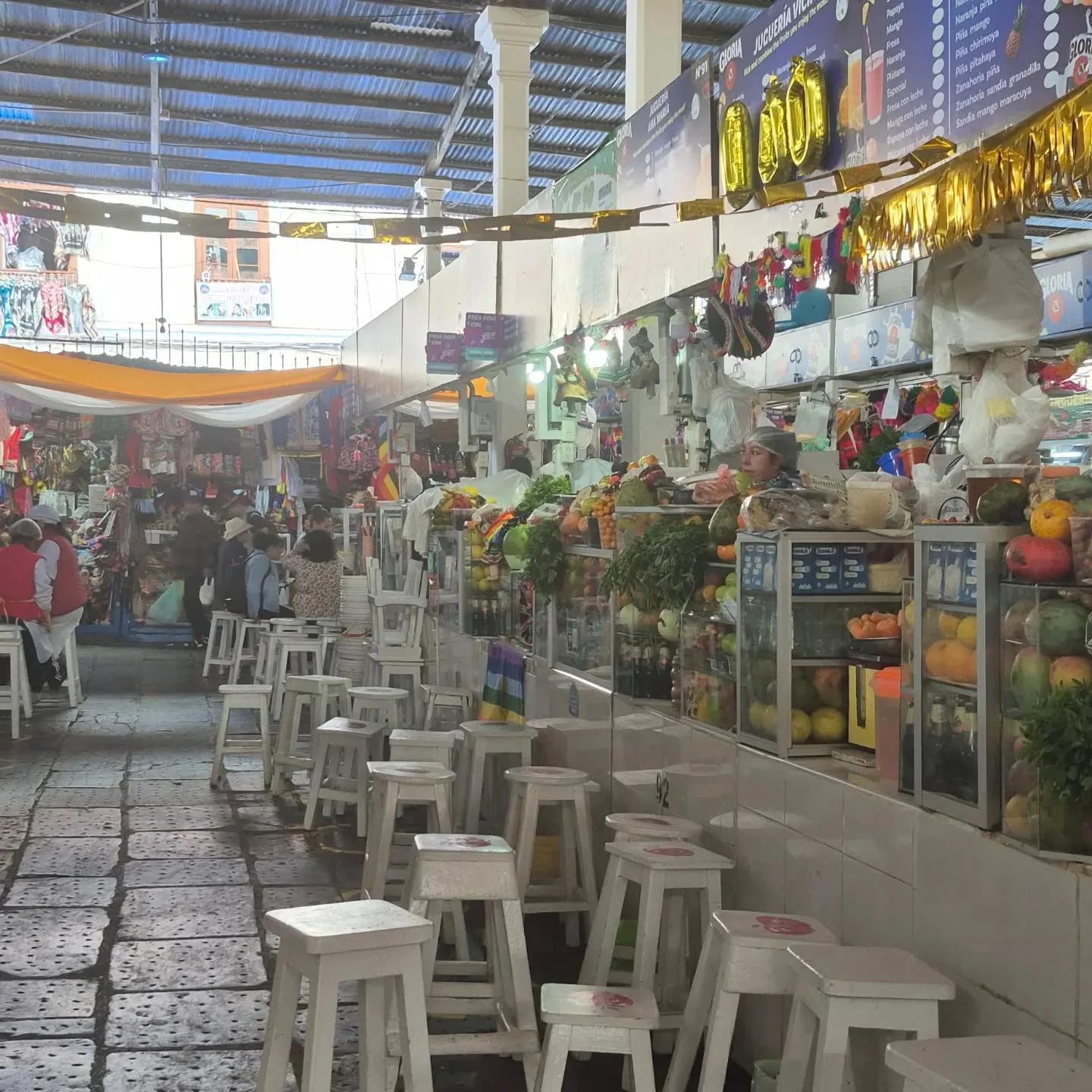 Ala das casas de suco do mercado, com bancos altos diante do balcão